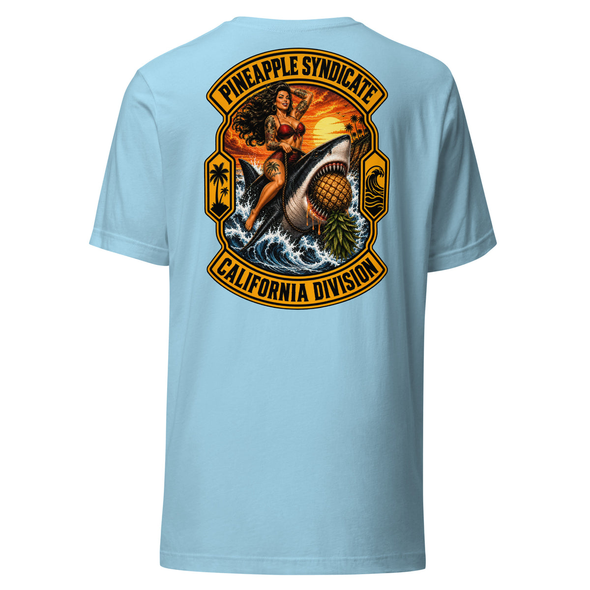 Pineapple Syndicate California Division tee featuring a tattooed pinup riding a great white shark through crashing waves with an upside-down pineapple, sunset coast, palm icons, and bold black-and-gold framing.
